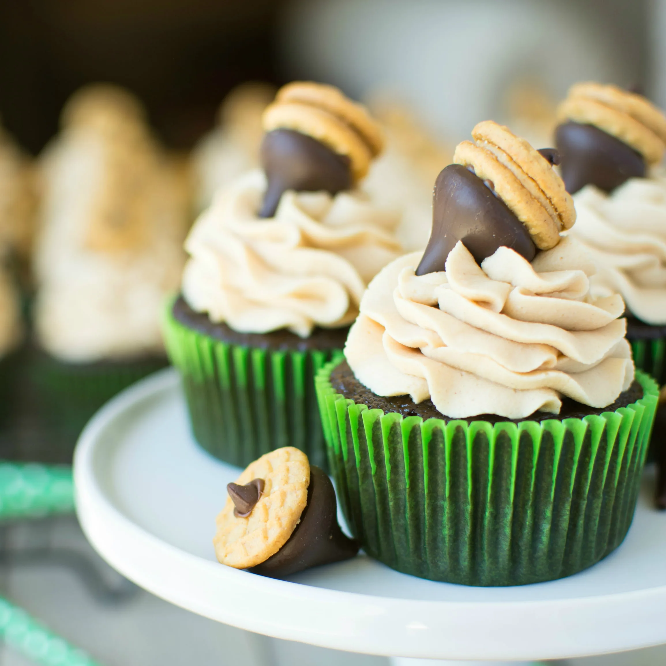 Wonderfully rich and fluffy, these chocolate cupcakes are topped with a creamy peanut butter frosting and crowned with a cute Hershey Kiss acorn!