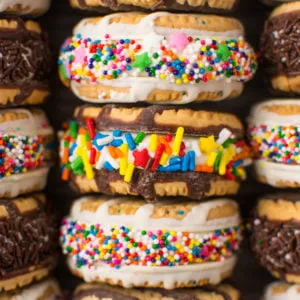 Rich and creamy no-churn cake batter ice cream sandwiched between Birthday Cake Fudge Stripe cookies and rolled in a rainbow of sprinkles!