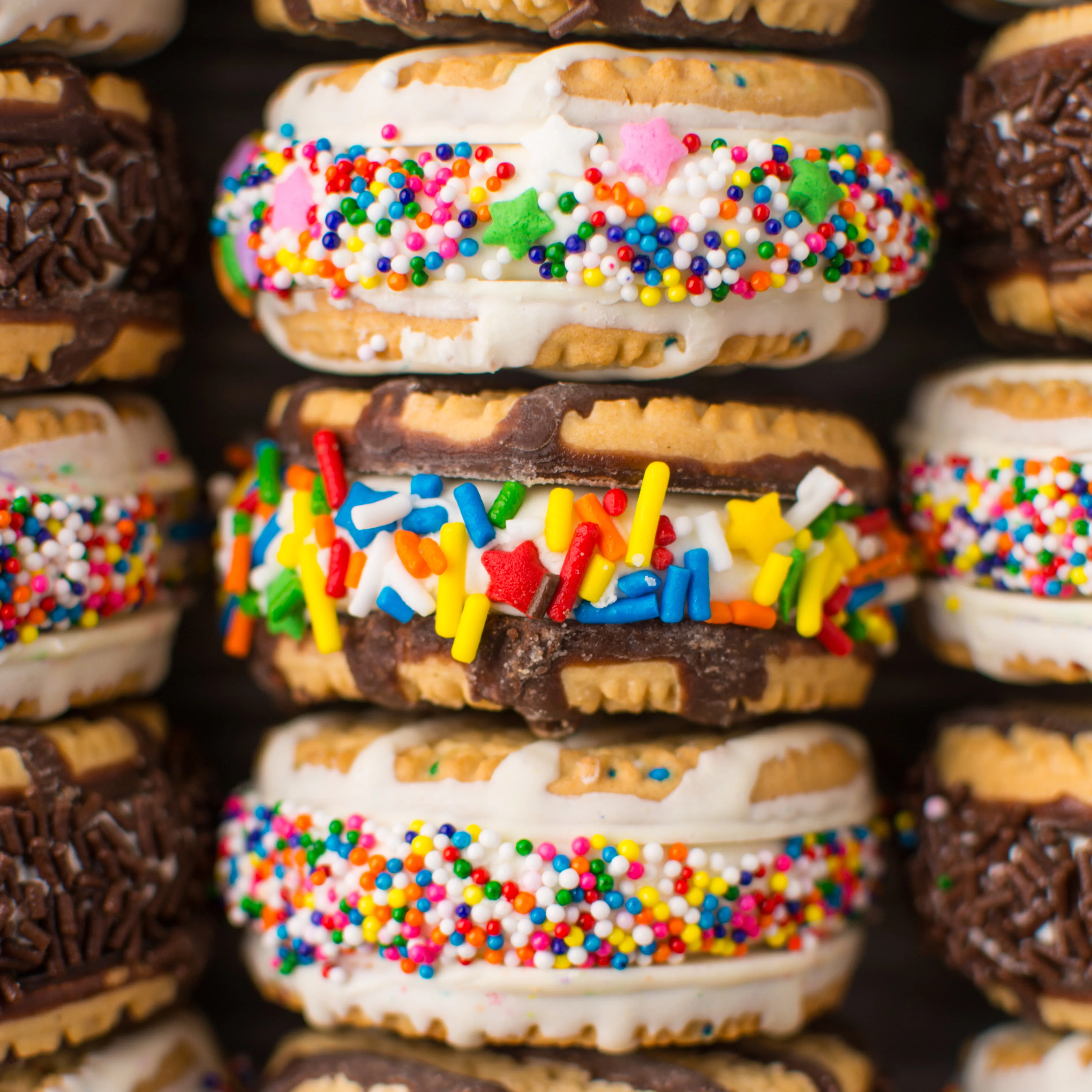 Rich and creamy no-churn cake batter ice cream sandwiched between Birthday Cake Fudge Stripe cookies and rolled in a rainbow of sprinkles!