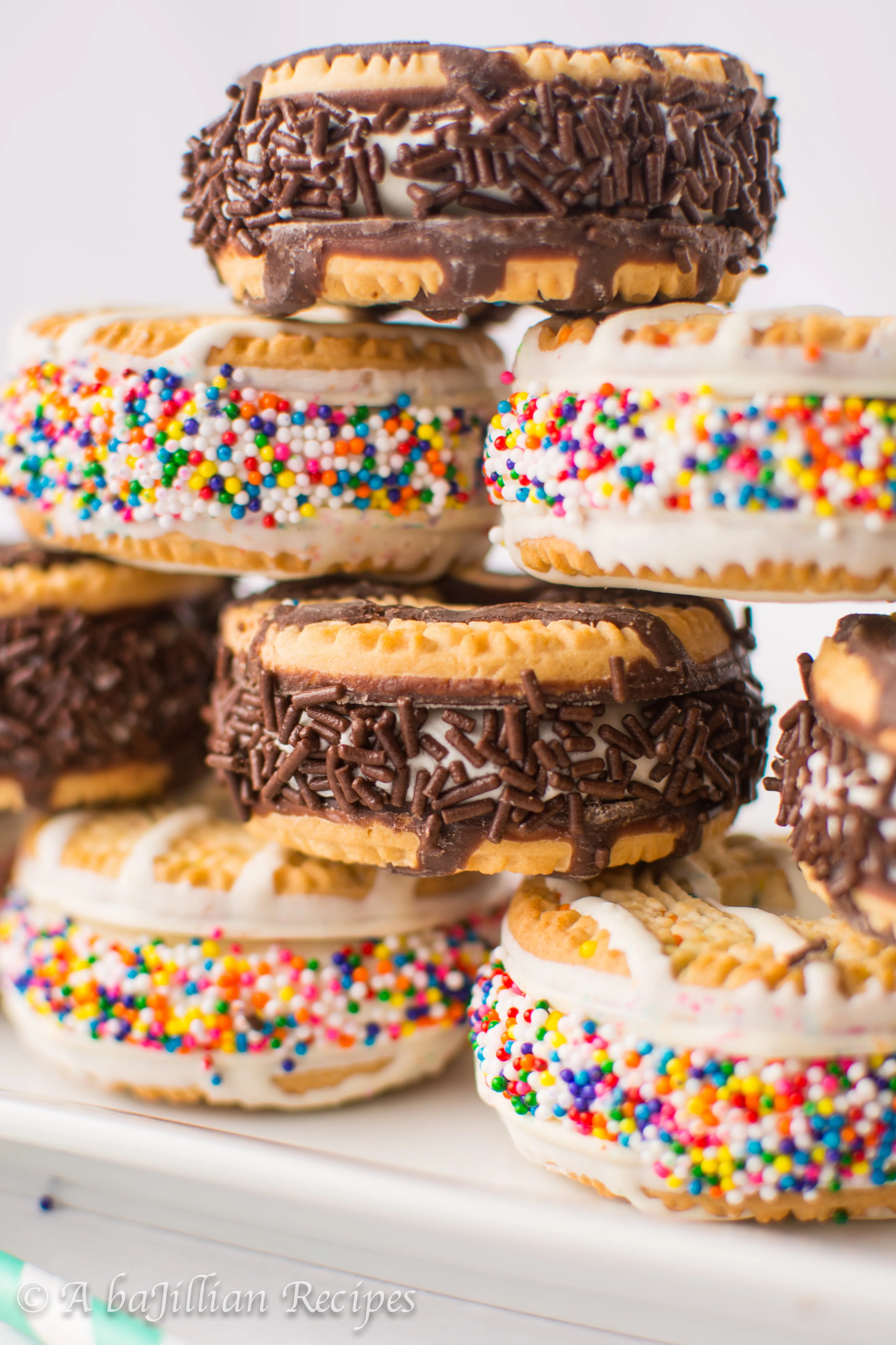 Rich and creamy no-churn cake batter ice cream sandwiched between Birthday Cake Fudge Stripe cookies and rolled in a rainbow of sprinkles!