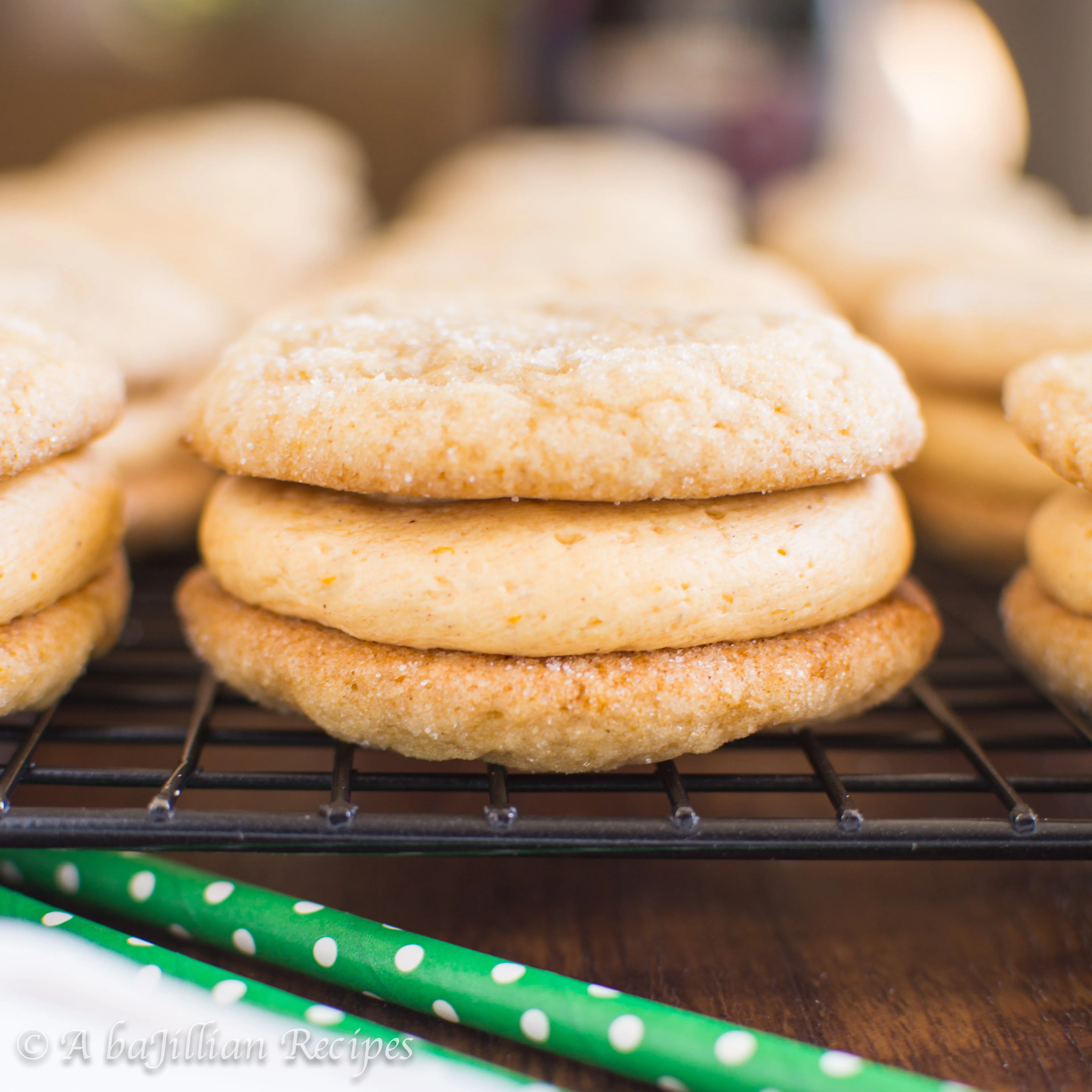 Soft and chewy sugar cookies infused with the warm sweetness of maple syrup, filled with a cloud of fluffy pumpkin buttercream frosting!