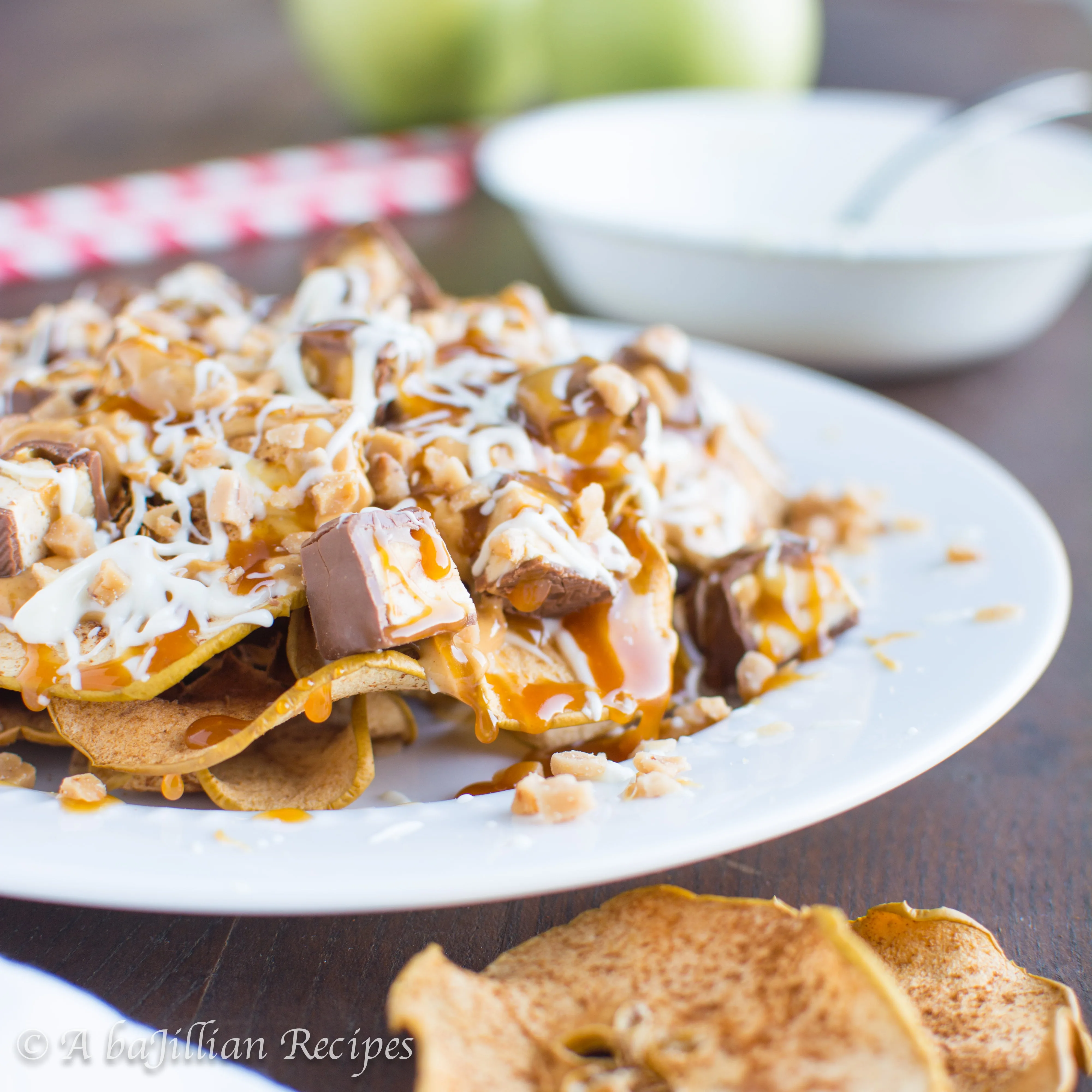 Crispy baked cinnamon apple chips loaded with caramel, white chocolate, peanut butter, Snickers, and toffee bits!