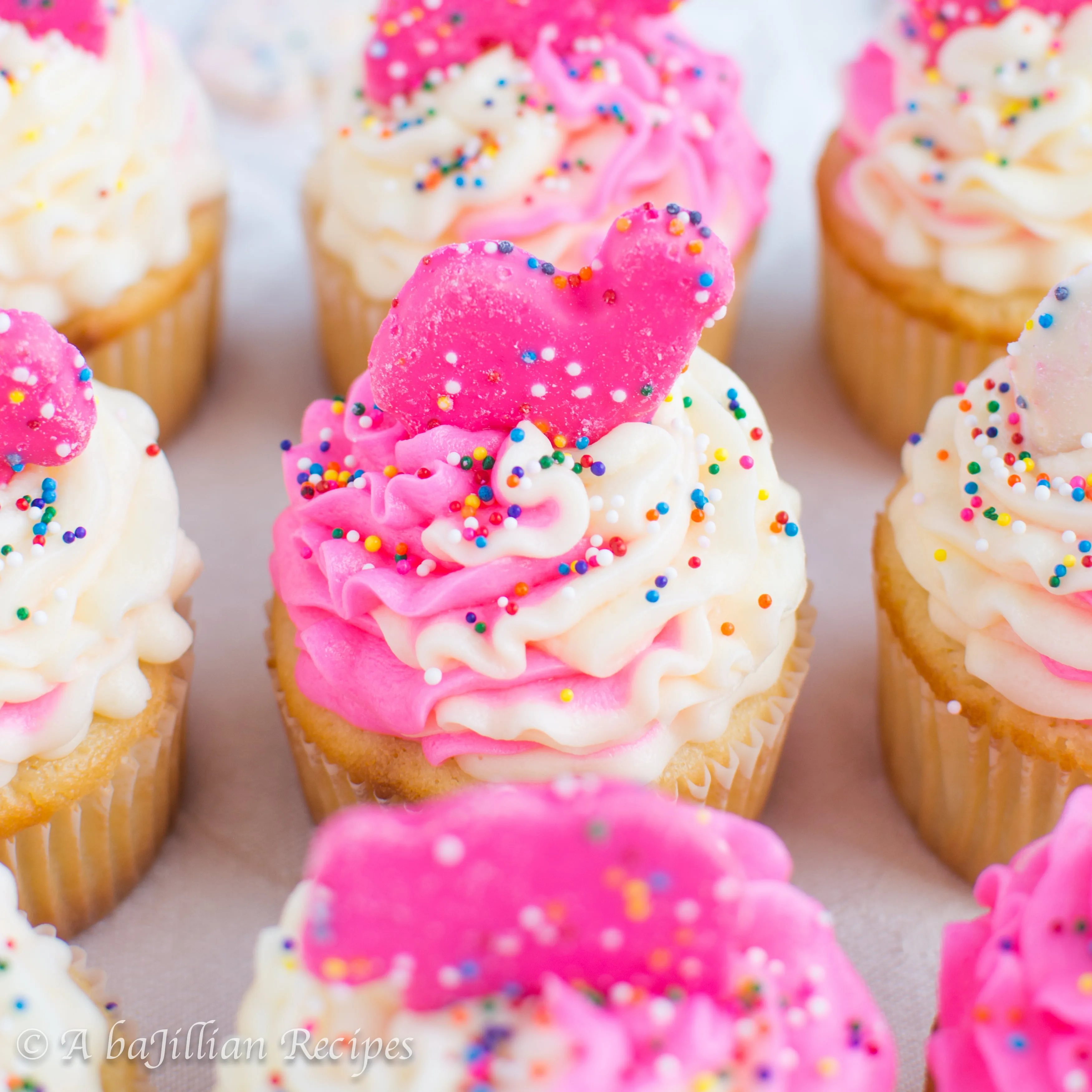 Fluffy white cupcakes filled with creamy animal cookie-speckled filling, topped with a pink and white ruffly swirl of buttercream and crowned with my all-time favorite cookie!