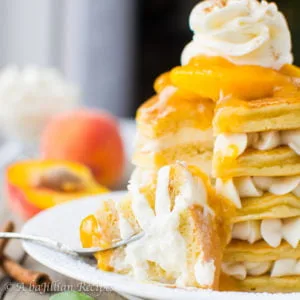 Fluffy pancakes layered with creamy white chocolate whipped filling and crowned with a bright and fruity peach topping!