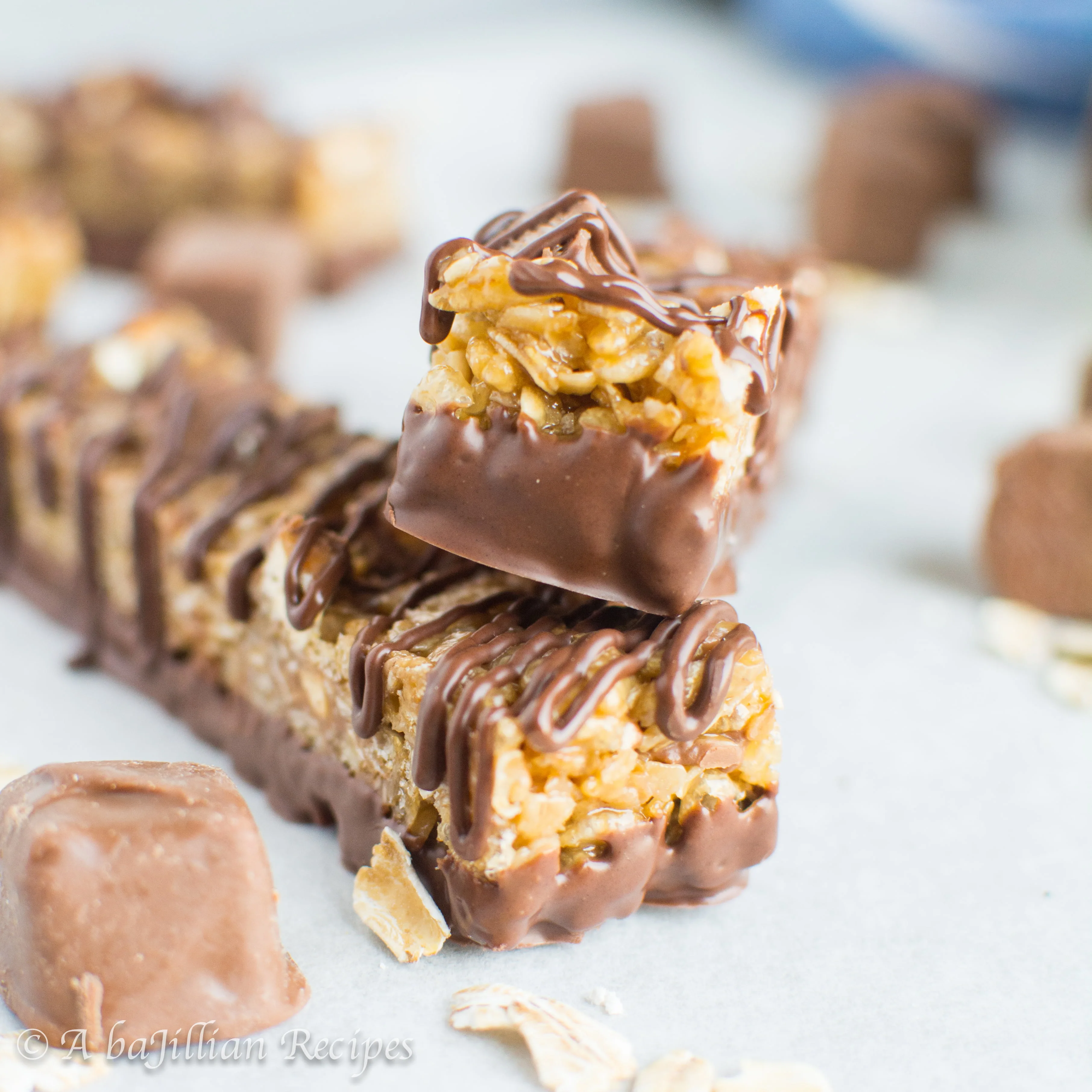 Soft and chewy granola bars loaded with Snickers then dipped and drizzled in chocolate! A 90's kid favorite made from scratch!