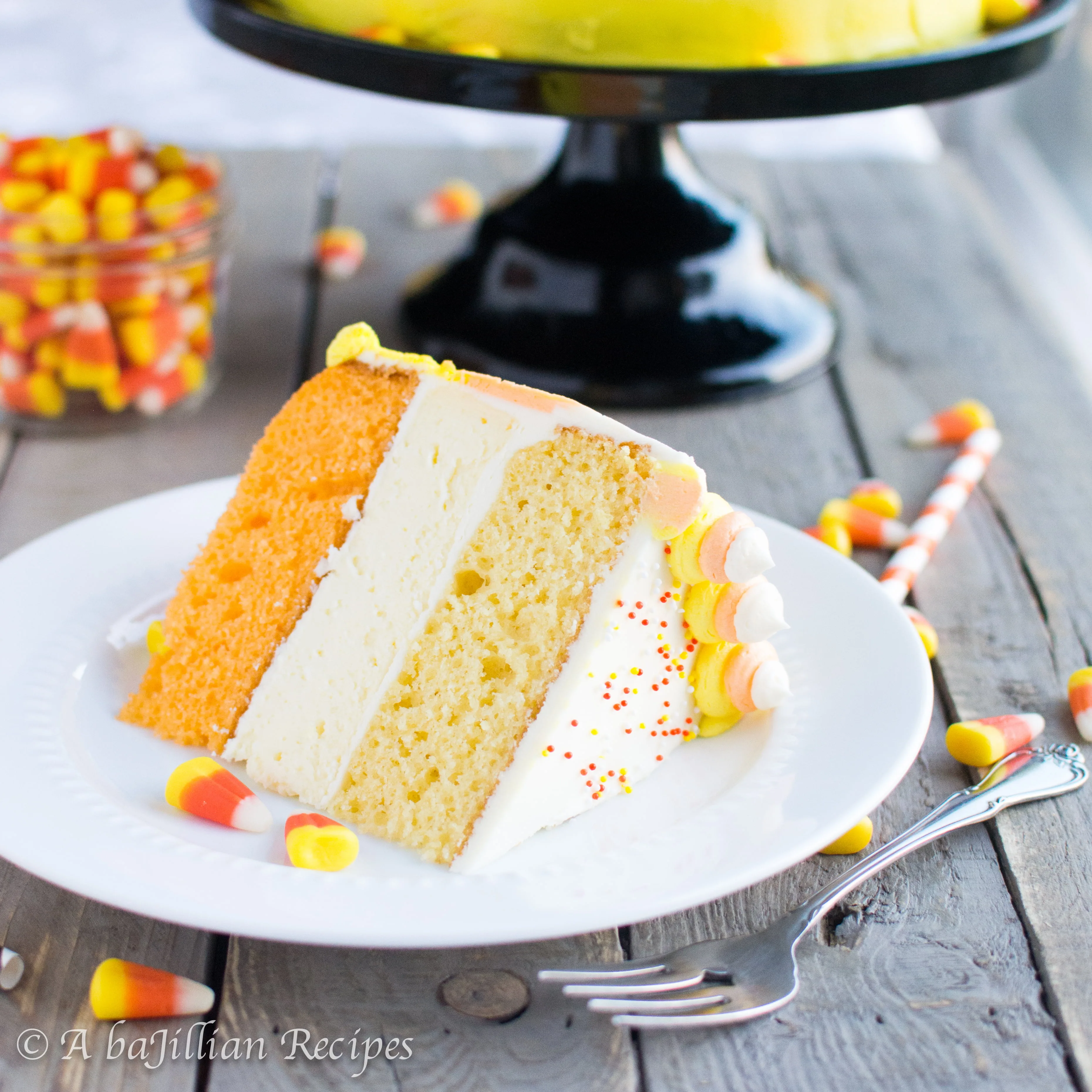 A fun and festive cake made with layers of fluffy cake and a rich and creamy layer of cheesecake, brilliantly frosted in candy corn colors!