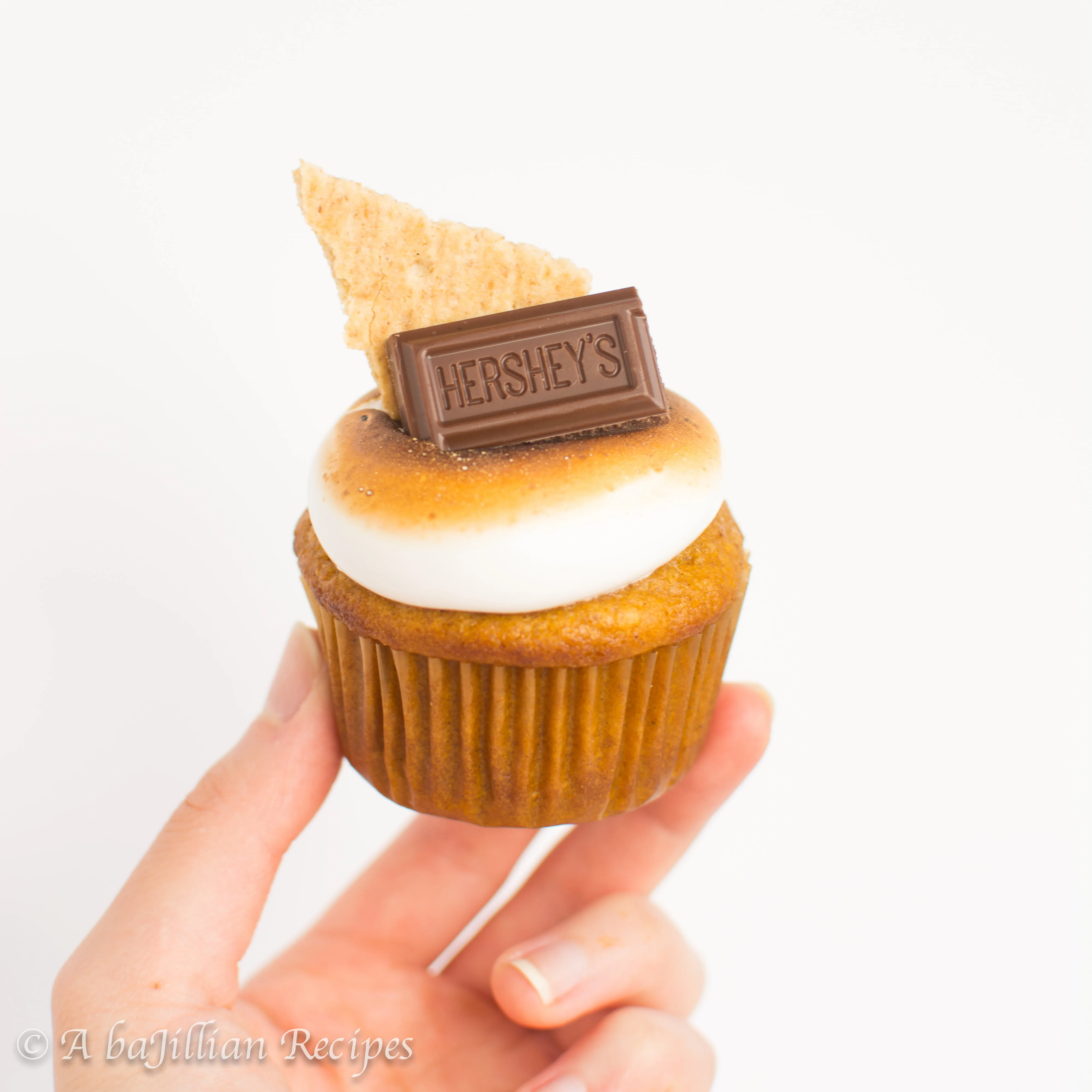 Sweet and cinnamony pumpkin-spiced cupcakes filled with rich chocolate ganache and topped with an elegant crown of toasted marshmallow frosting!