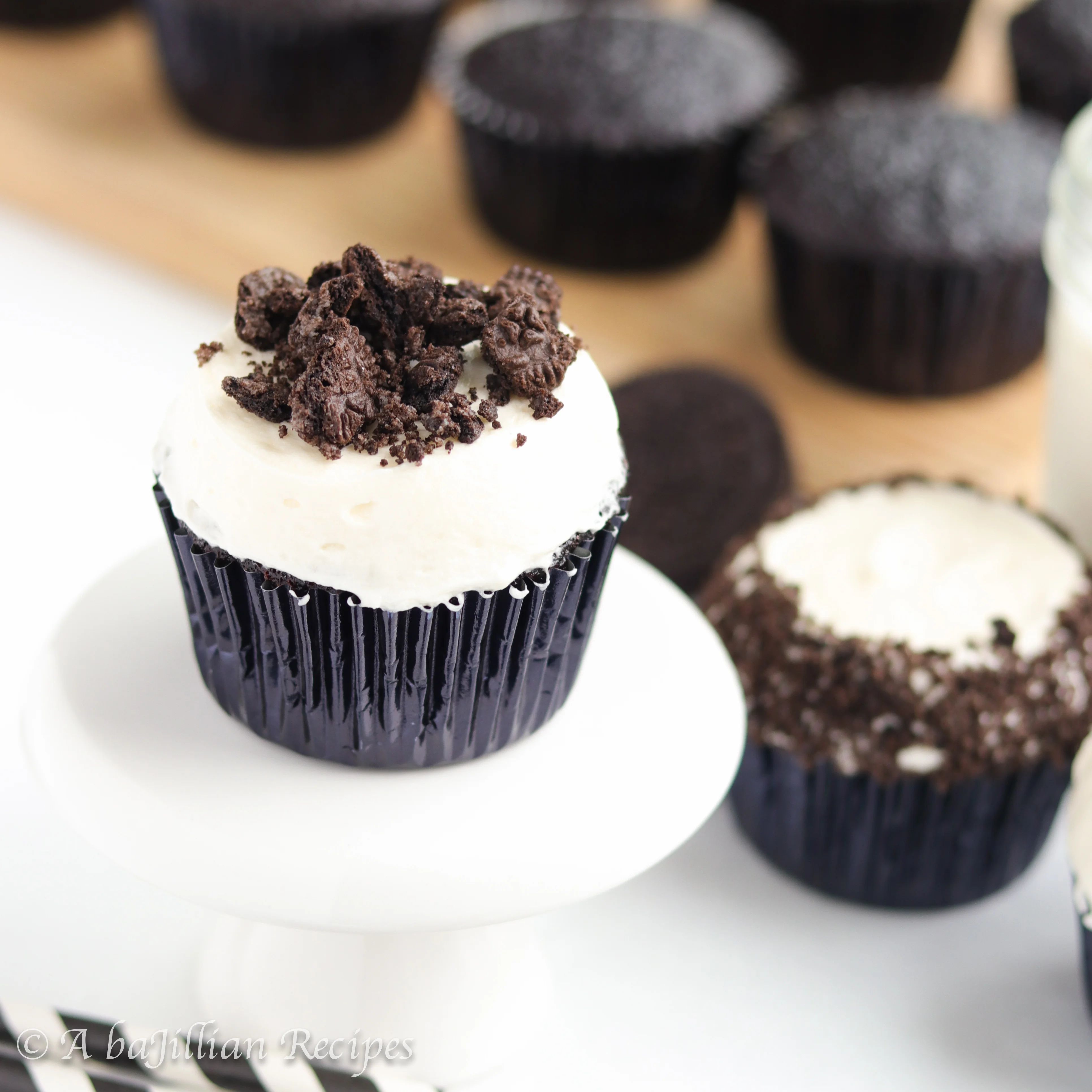 Chocolate Oreo cupcakes baked with a surprise Oreo in the bottom, topped with a creamy vanilla buttercream, and crowned with more crushed Oreos!