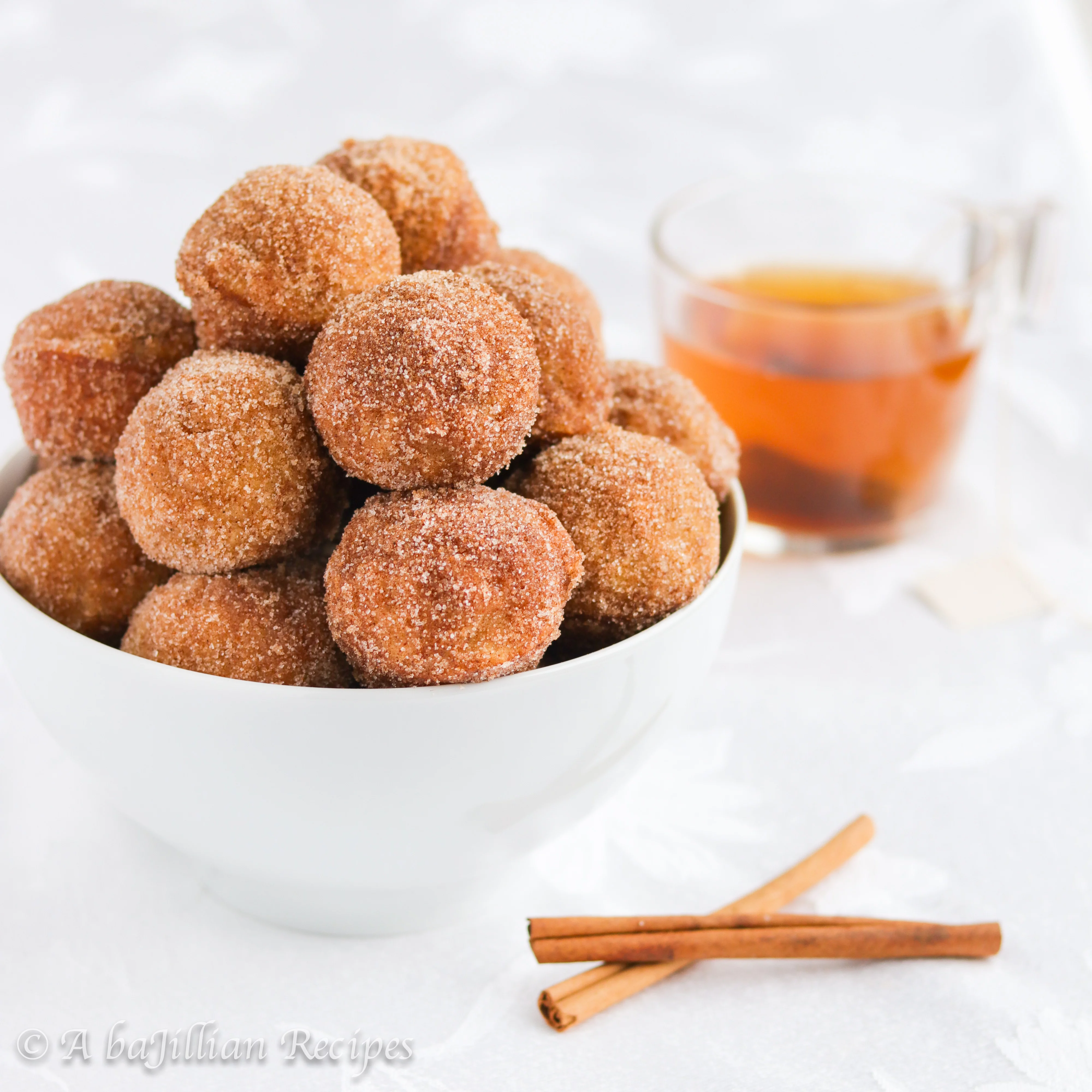 Soft and pillowy donut muffins infused with delicious apple cider and fall spices, coated in butter and cinnamon-sugar!