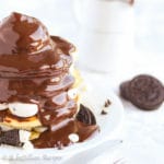 Fluffy pancakes speckled with Oreos, layered with cookies n' creme cheesecake filling, and topped with rich chocolate ganache!
