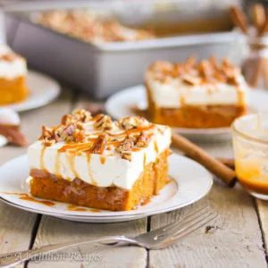 Moist and perfectly-spiced pumpkin cake soaked in caramel, topped with sweetened cream cheese filling, and sprinkled with toasted pecans!