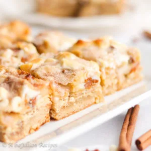 Layers upon layers of deliciousness in these ooey gooey Snickerdoodle Magic Bars! The bars are layered with a snickerdoodle cookie crust, Brown Sugar Cinnamon Pop-Tarts, marshmallows, cinnamon chips, white chocolate chips, and sweetened condensed milk. Cinnamon sugar heaven!