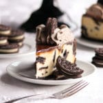 This Oreo Cheesecake is rich, dense, and supremely creamy! It's baked in an Oreo cookie crust, studded with delicious Oreos, topped with chocolate ganache, and crowned with the most luscious Oreo whipped cream!