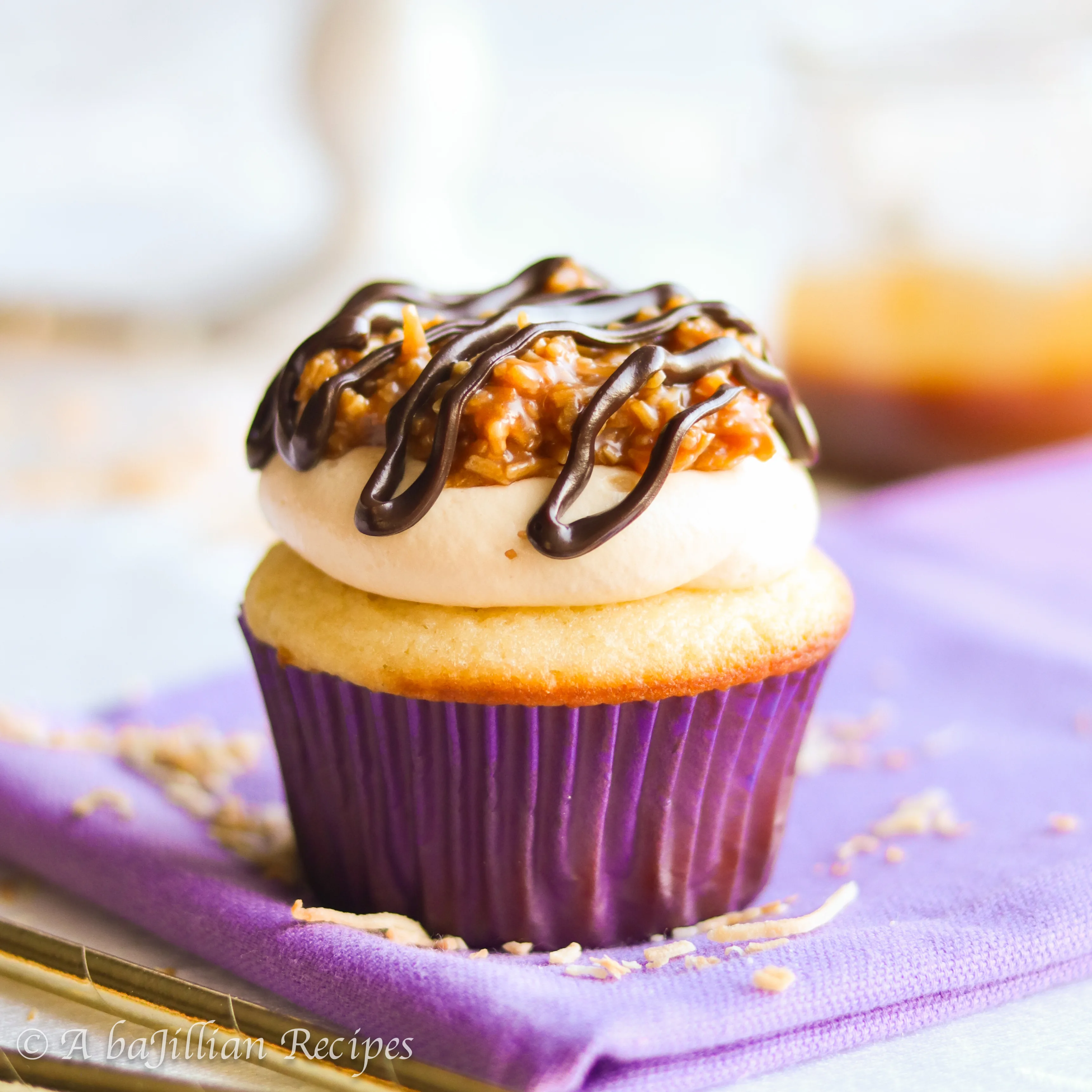 Fluffy vanilla cupcakes topped with a silky caramel swiss meringue buttercream, a decadent crown of caramel coconut topping, and a drizzle of chocolate ganache!