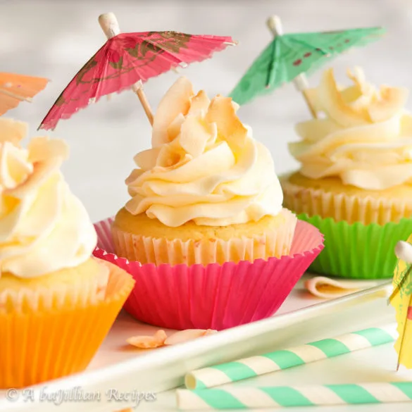 Moist and fluffy pineapple cupcakes filled with a luscious pineapple curd and finished off with a crown of coconut buttercream!