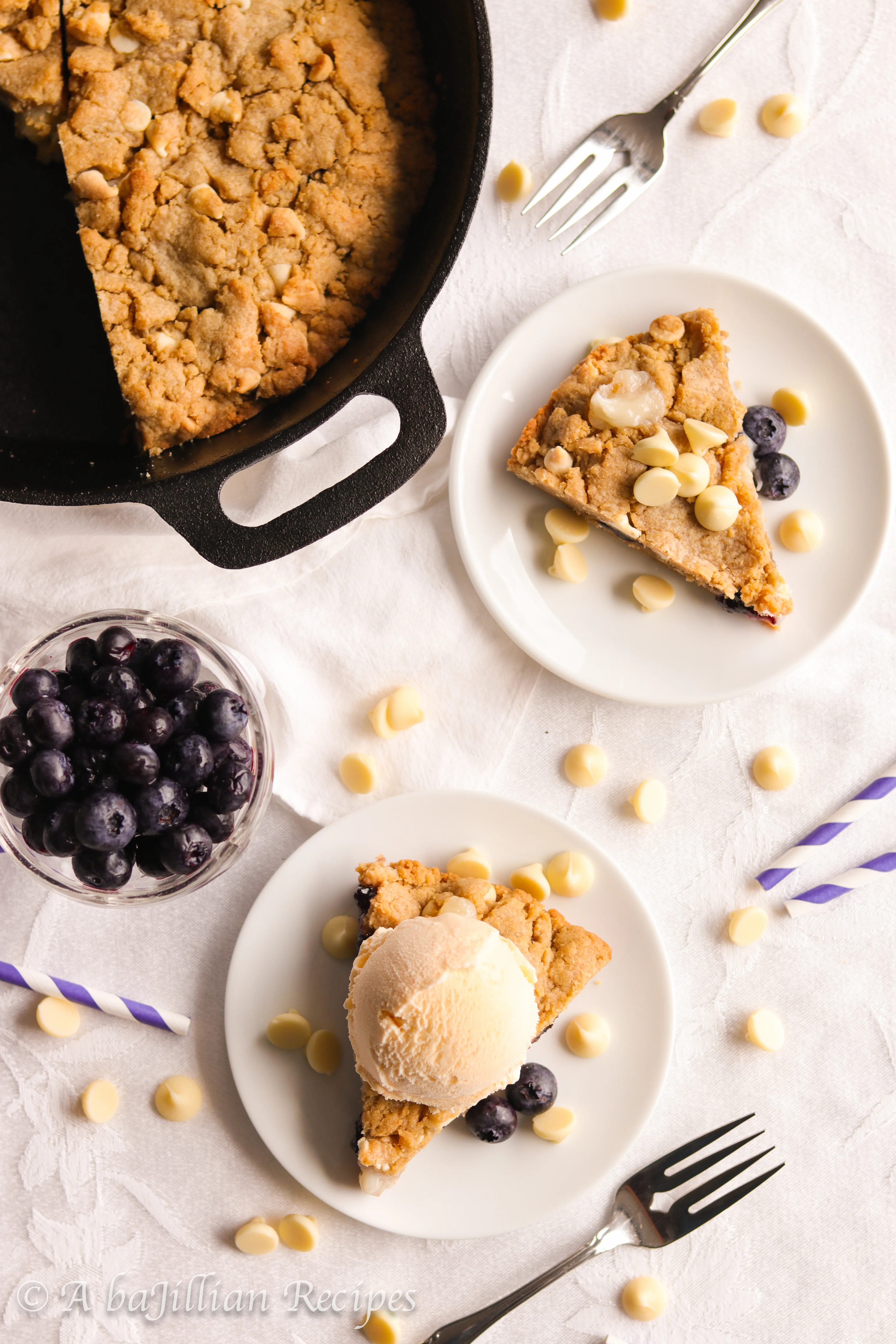 A warm, soft, and deliciously doughy graham-flavored cookie brimming with melty white chocolate chips, pockets of blueberry jam and cream cheese filling!