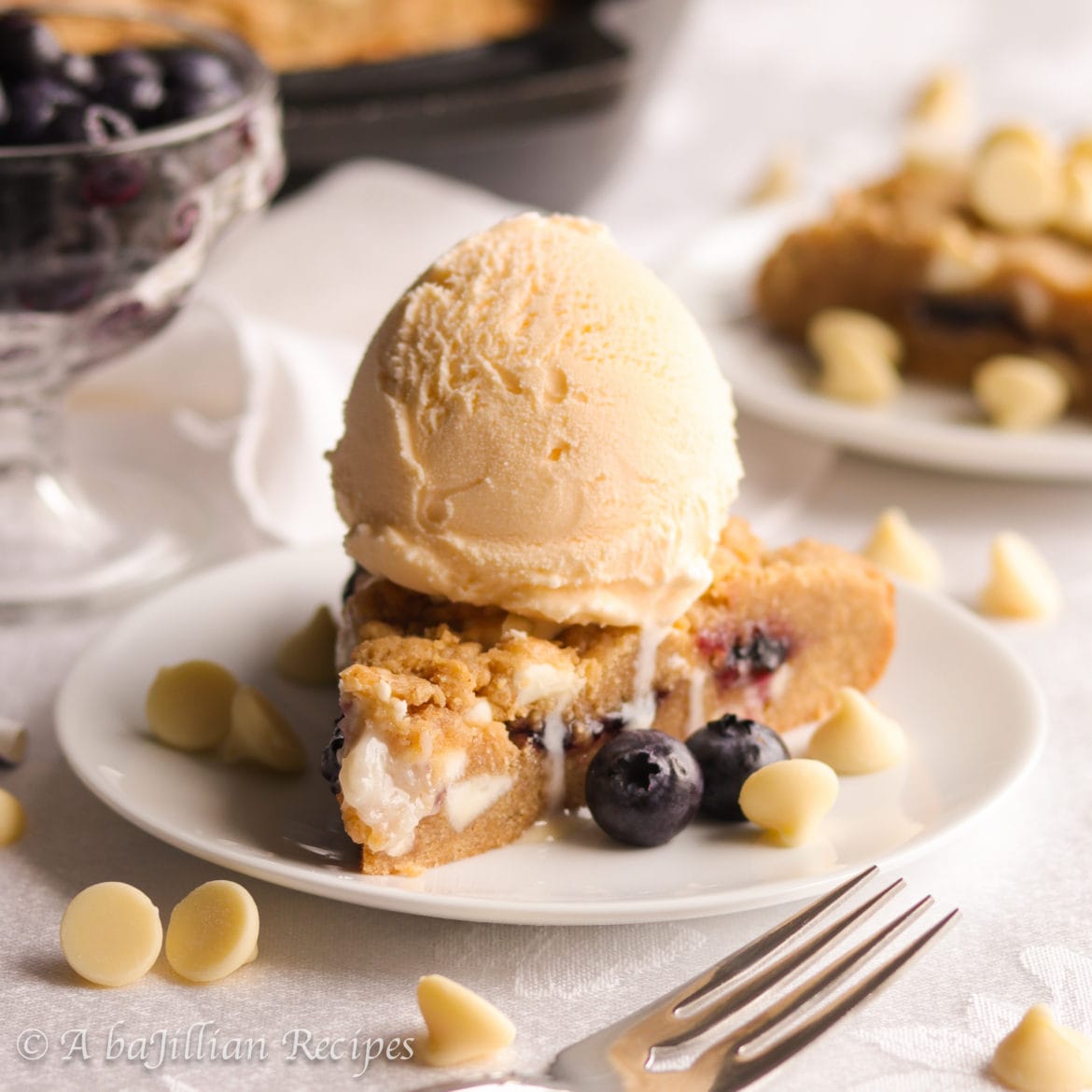 A warm, soft, and deliciously doughy graham-flavored cookie brimming with melty white chocolate chips, pockets of blueberry jam and cream cheese filling!