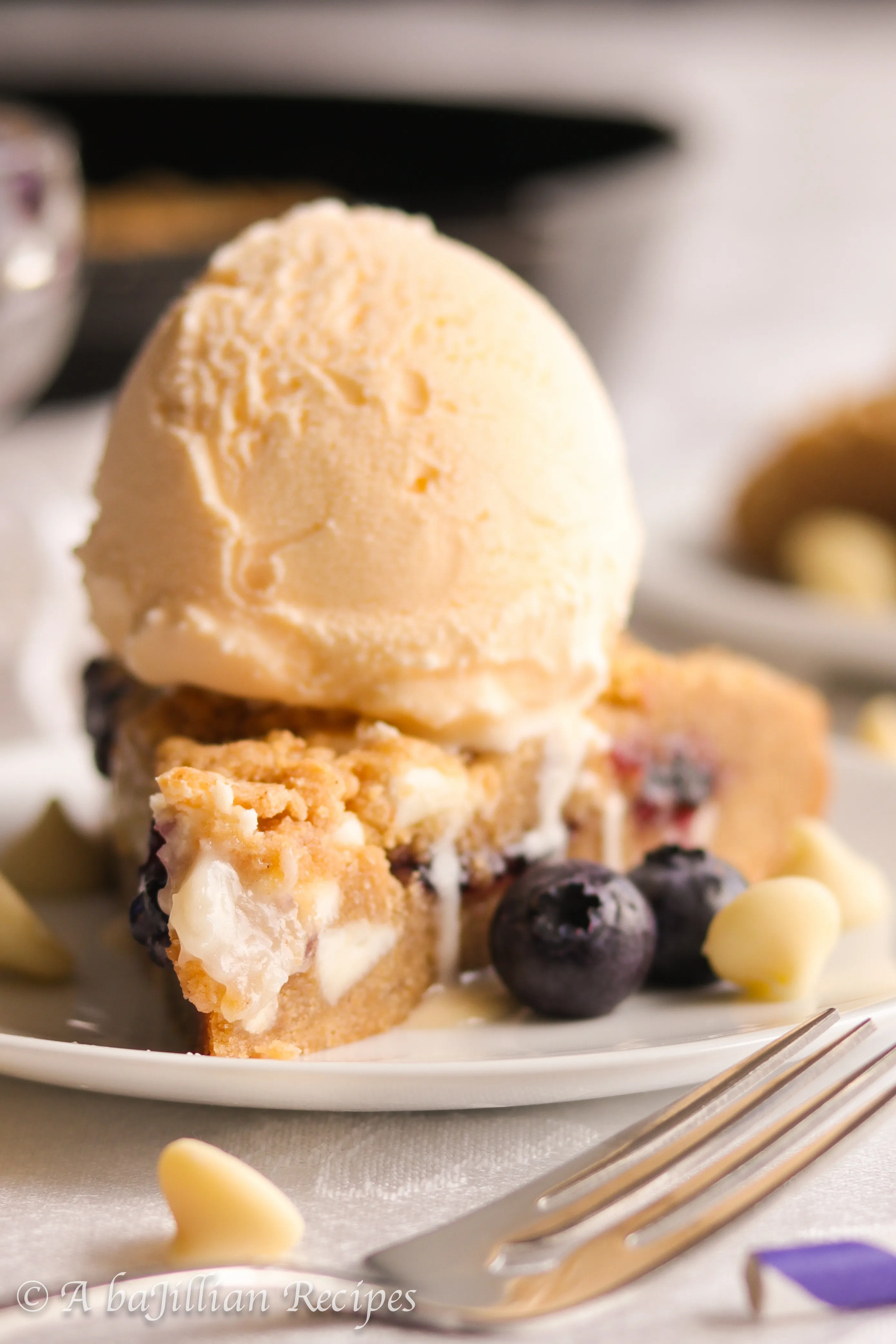 A warm, soft, and deliciously doughy graham-flavored cookie brimming with melty white chocolate chips, pockets of blueberry jam and cream cheese filling!