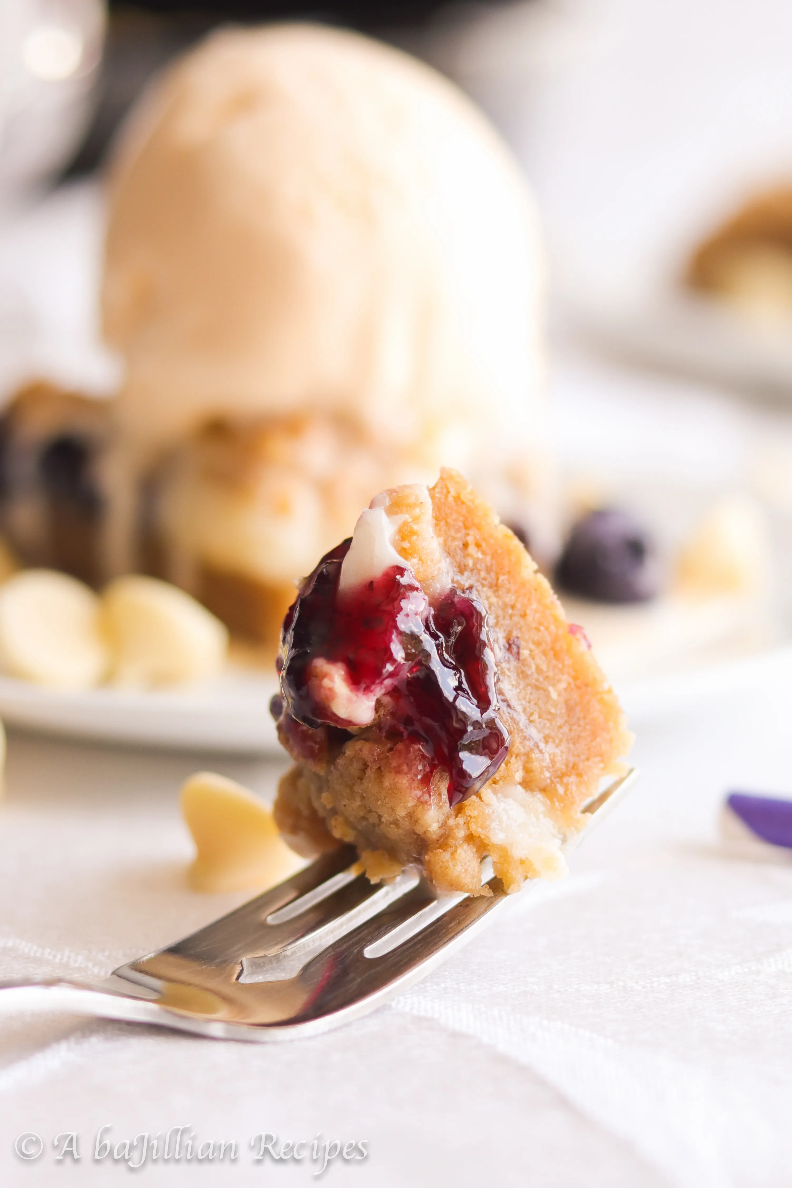 A warm, soft, and deliciously doughy graham-flavored cookie brimming with melty white chocolate chips, pockets of blueberry jam and cream cheese filling!