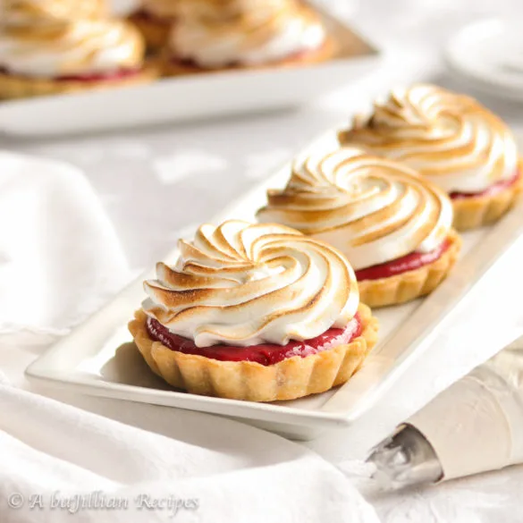 Lusciously tart raspberry curd in a buttery flakey crust and crowned with the fluffiest Italian meringue!