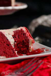 Moist layers of cocoa-kissed red velvet cake frosted with silky smooth vanilla Swiss meringue buttercream frosting! It's also drizzled in white chocolate ganache "blood" and adorned with "broken glass" sugar shards. A bloody good cake indeed!