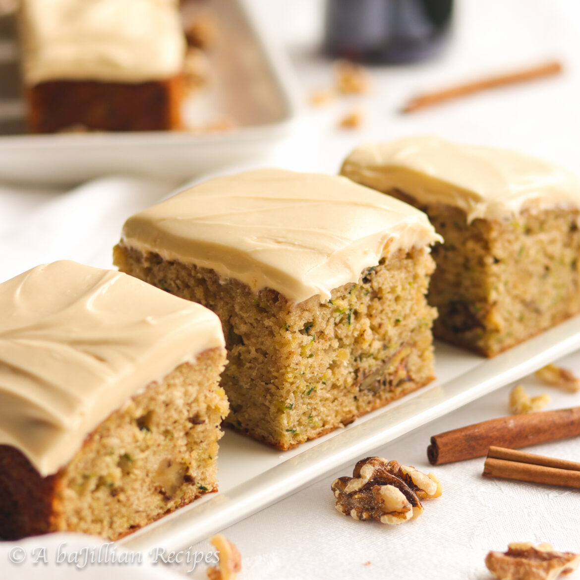 Supremely moist and fluffy zucchini cake spiced with cinnamon, loaded with toasted walnuts, and slathered in a rich and creamy maple-kissed cream cheese frosting!