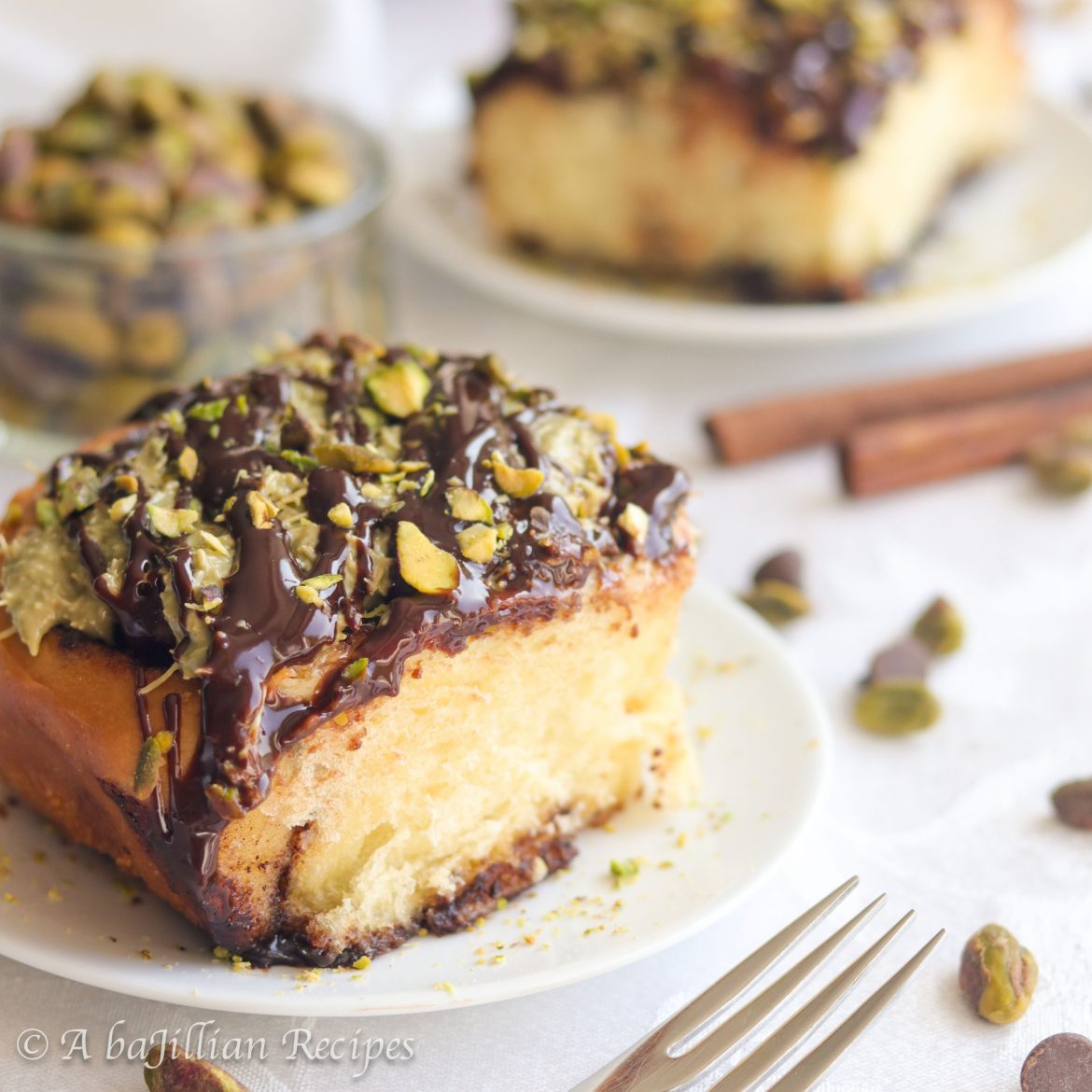 Soft and pillowy cinnamon rolls swirled with a cinnamon chocolate filling, topped with a creamy yet irresistibly crispy pistachio topping, and drizzled in rich chocolate ganache! 
