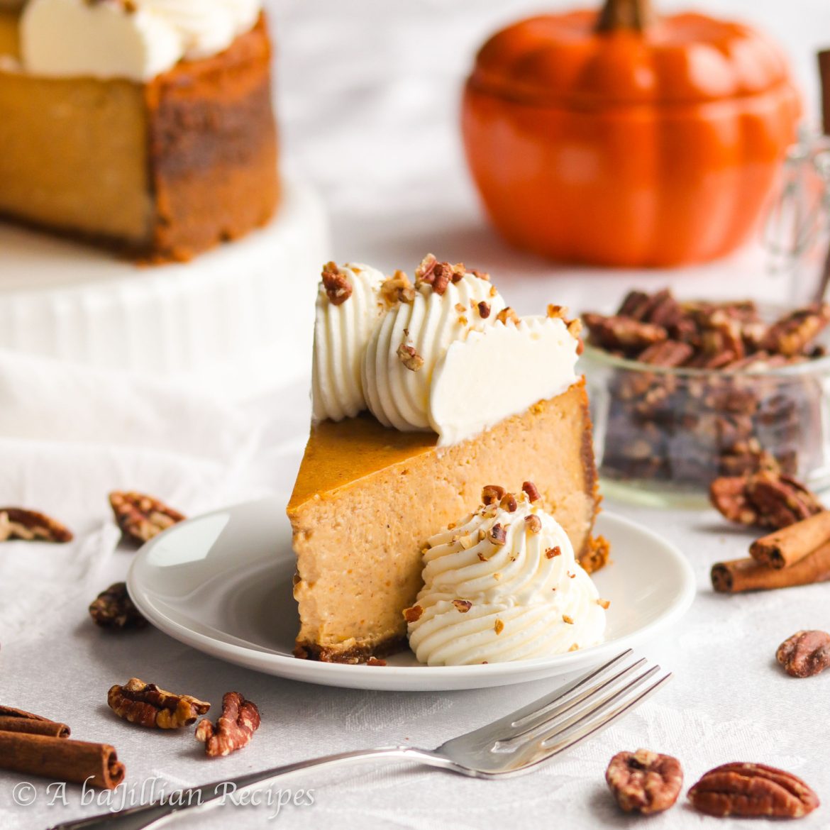 Tall, rich, and incredibly creamy, this Pumpkin Cheesecake is infused with warm spices, baked in a buttery Biscoff cookie crust, and crowned with fluffy cream cheese whipped cream!