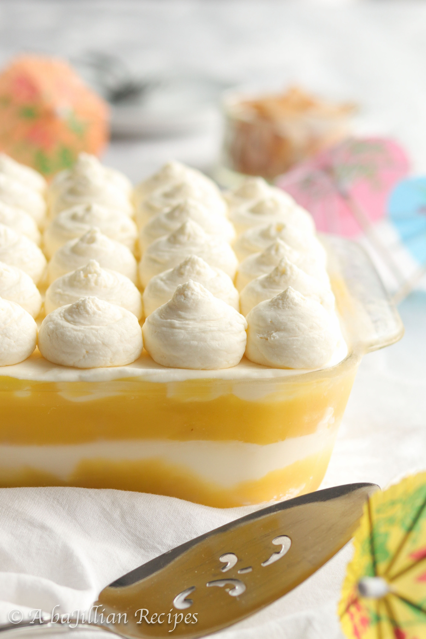 This Piña Colada Tiramisu contains layers of pineapple syrup-soaked ladyfingers, lusciously tangy pineapple curd, and fluffy coconut-kissed mascarpone filling!