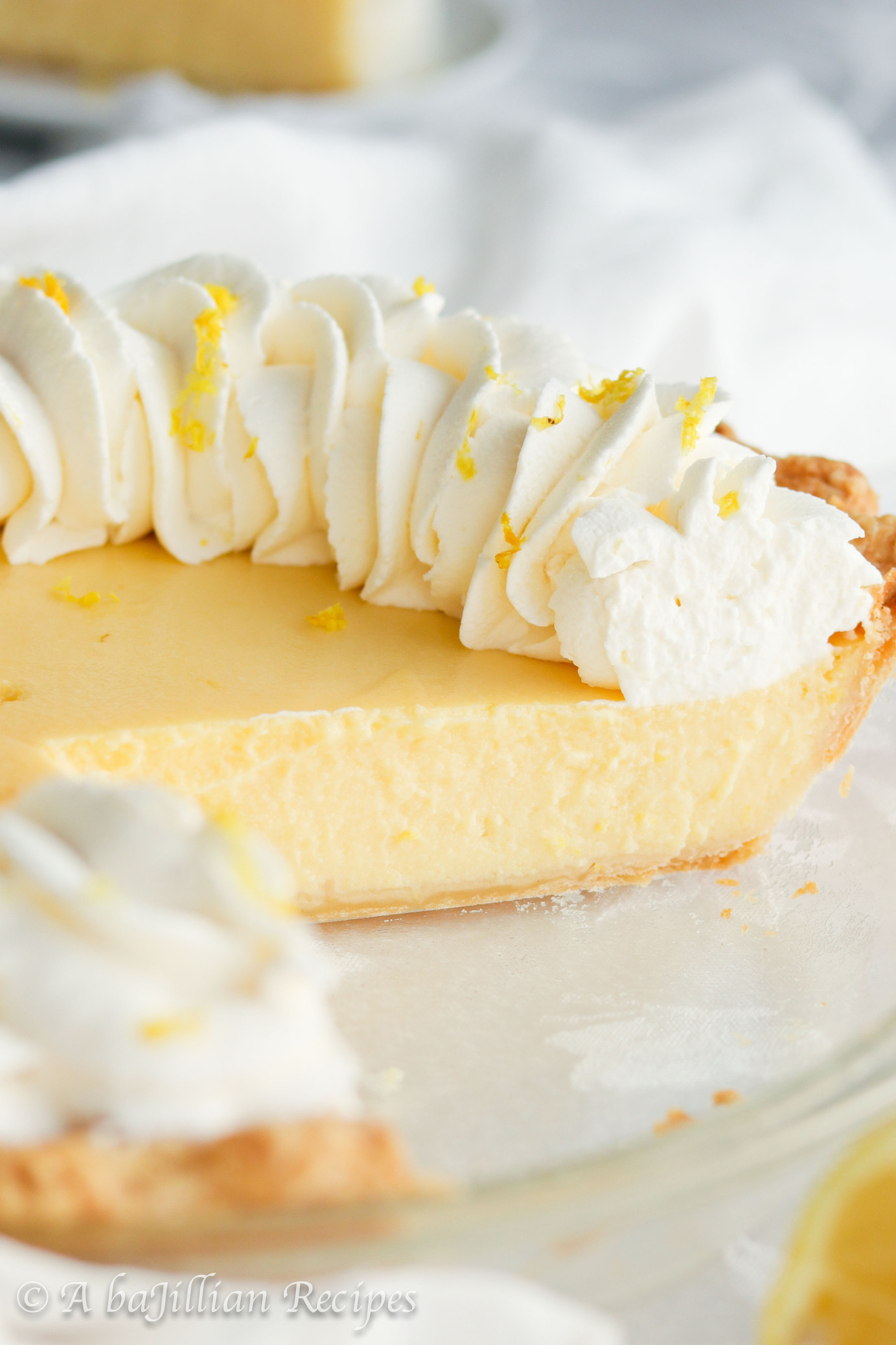 Smooth and creamy lemon filling nestled in a golden flaky pastry crust and crowned with a fluffy border of lemon-kissed whipped cream.