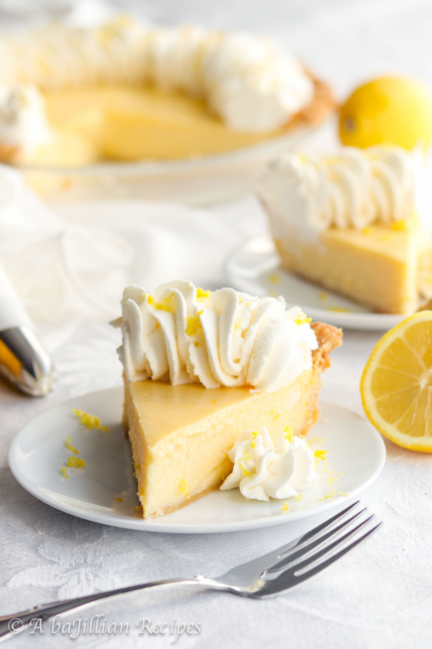 Smooth and creamy lemon filling nestled in a golden flaky pastry crust and crowned with a fluffy border of lemon-kissed whipped cream.