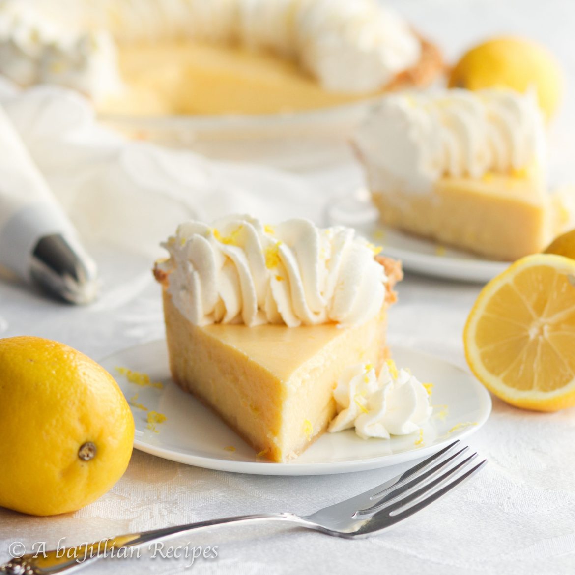 Smooth and creamy lemon filling nestled in a golden flaky pastry crust and crowned with a fluffy border of lemon-kissed whipped cream.