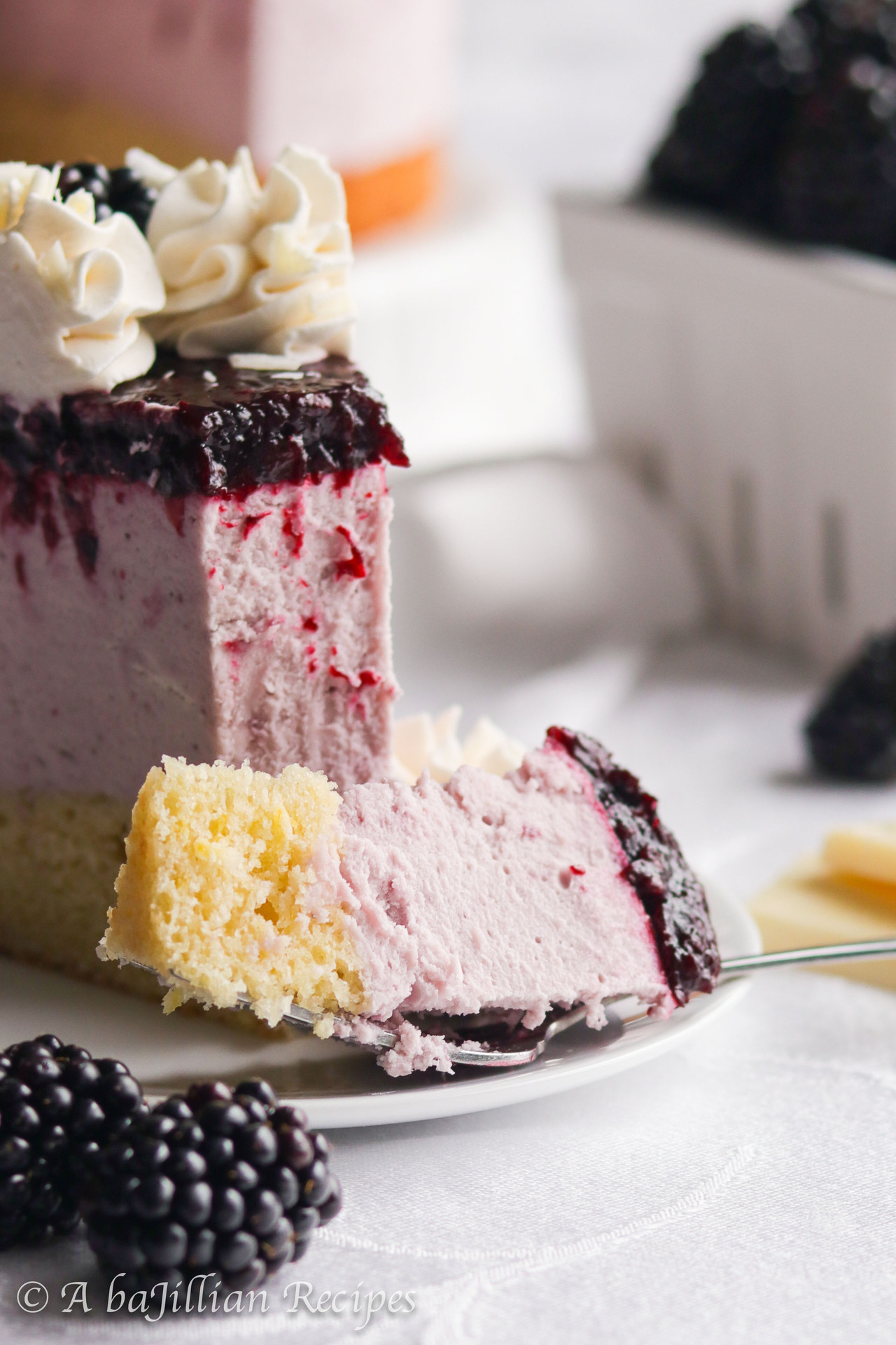 Both elegant and heavenly, this Blackberry White Chocolate Mousse Cake features moist and tender vanilla cake, blackberry white chocolate mousse, and luscious blackberry topping!