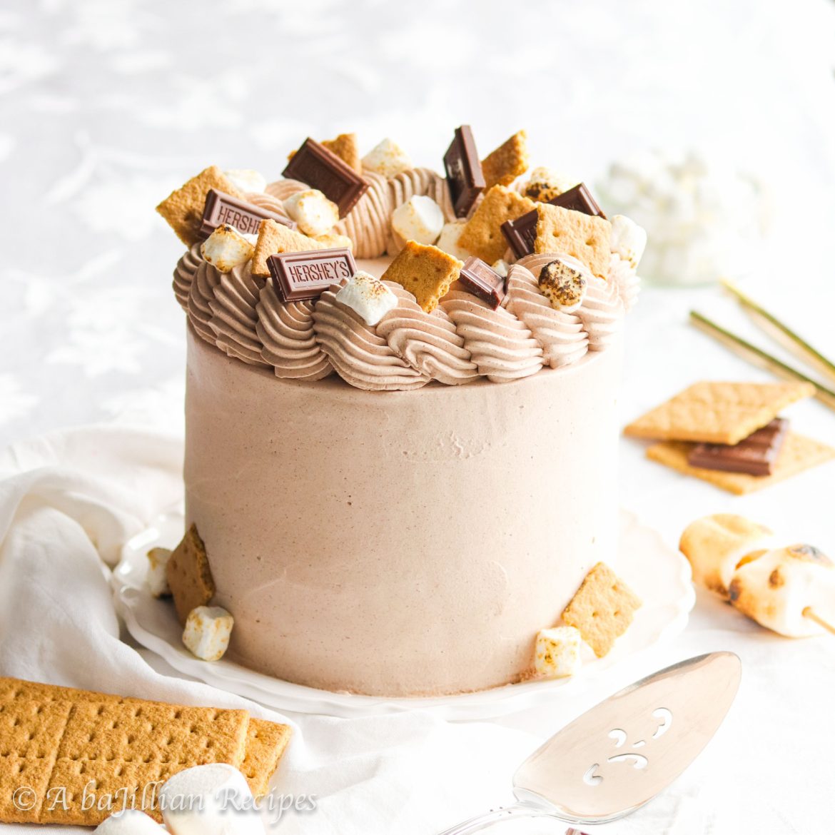 This S'more Ice Cream Cake features layers of creamy chocolate ice cream, toasted marshmallow ice cream, rich fudge sauce, and crisp graham cracker crust! 